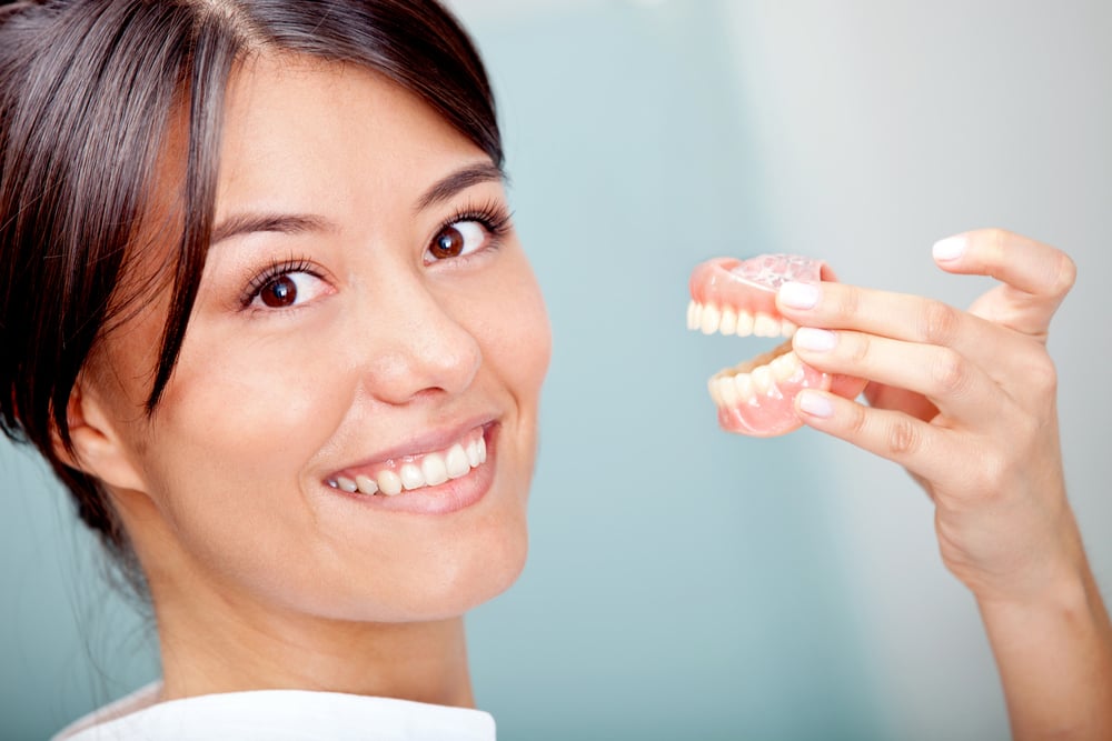 Woman holding a teeth sample or prosthesis at the dentist-3