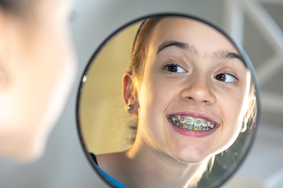 caucasian-preteen-girl-with-braces-her-teeth-looking-mirror