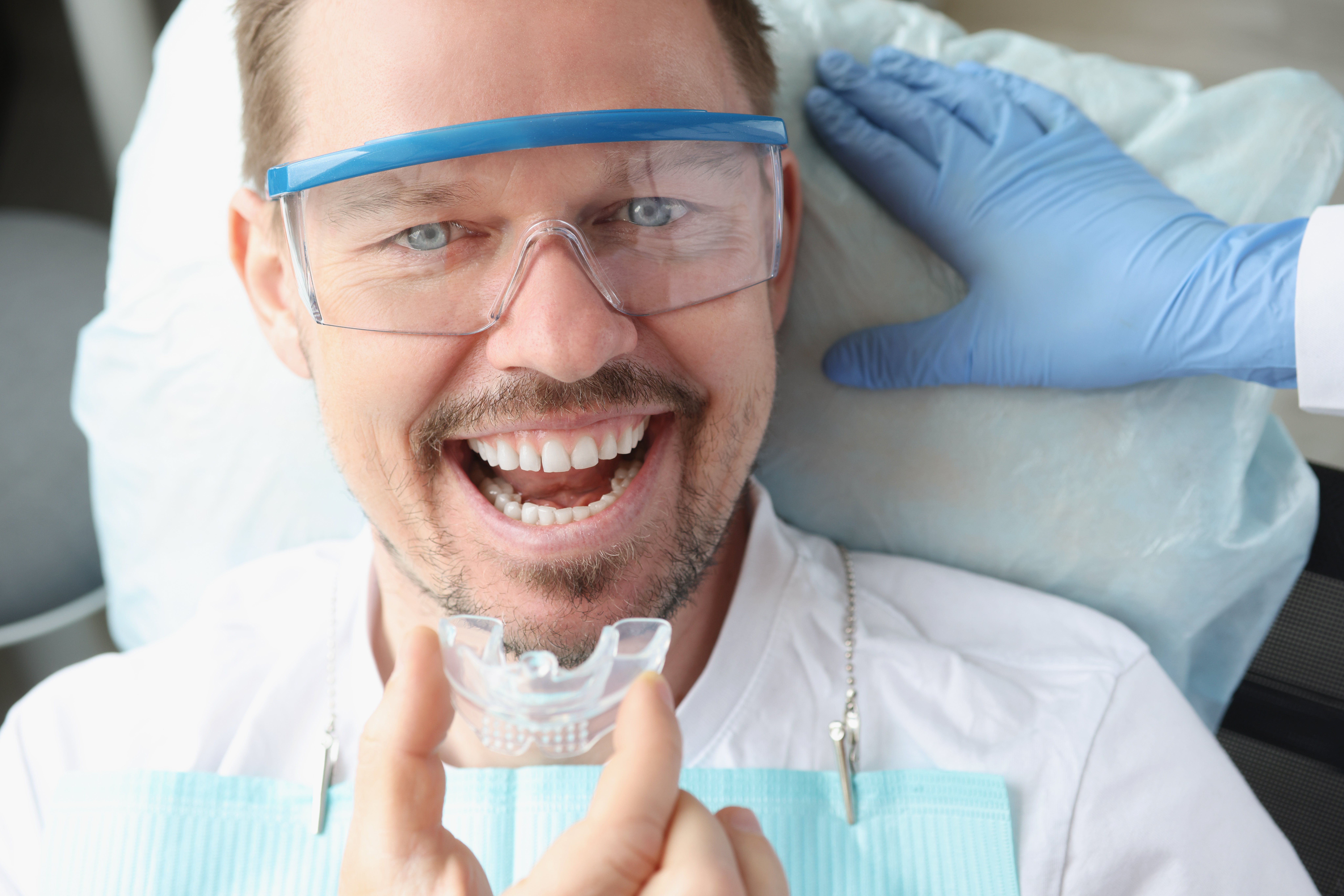 dentist-doctor-inserting-plastic-night-guard-man-dental-office