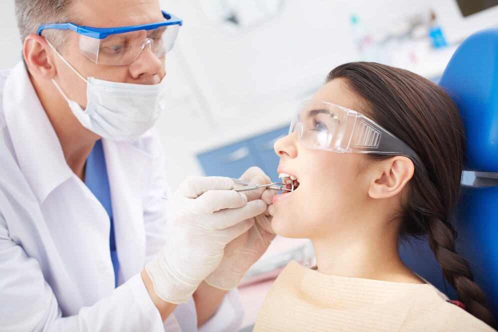dentist-examining-patient-s-teeth_1098-1540