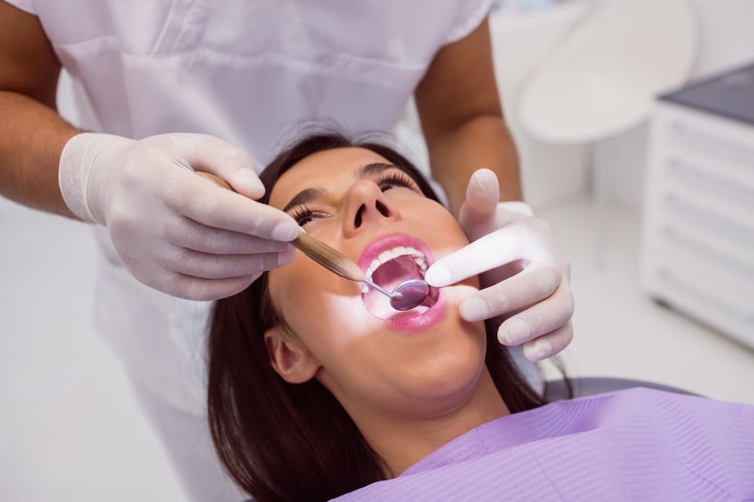 dentist-examining-patient-teeth-with-mouth-mirror