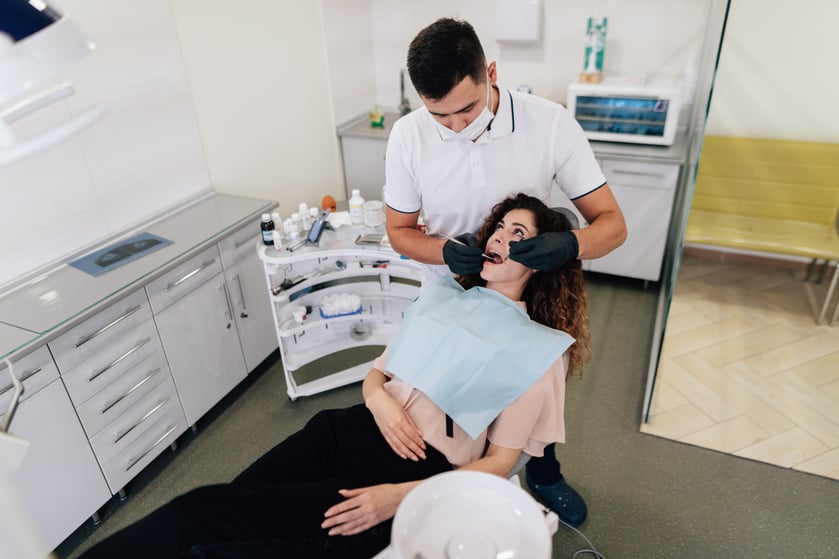 dentist-performing-check-up-woman