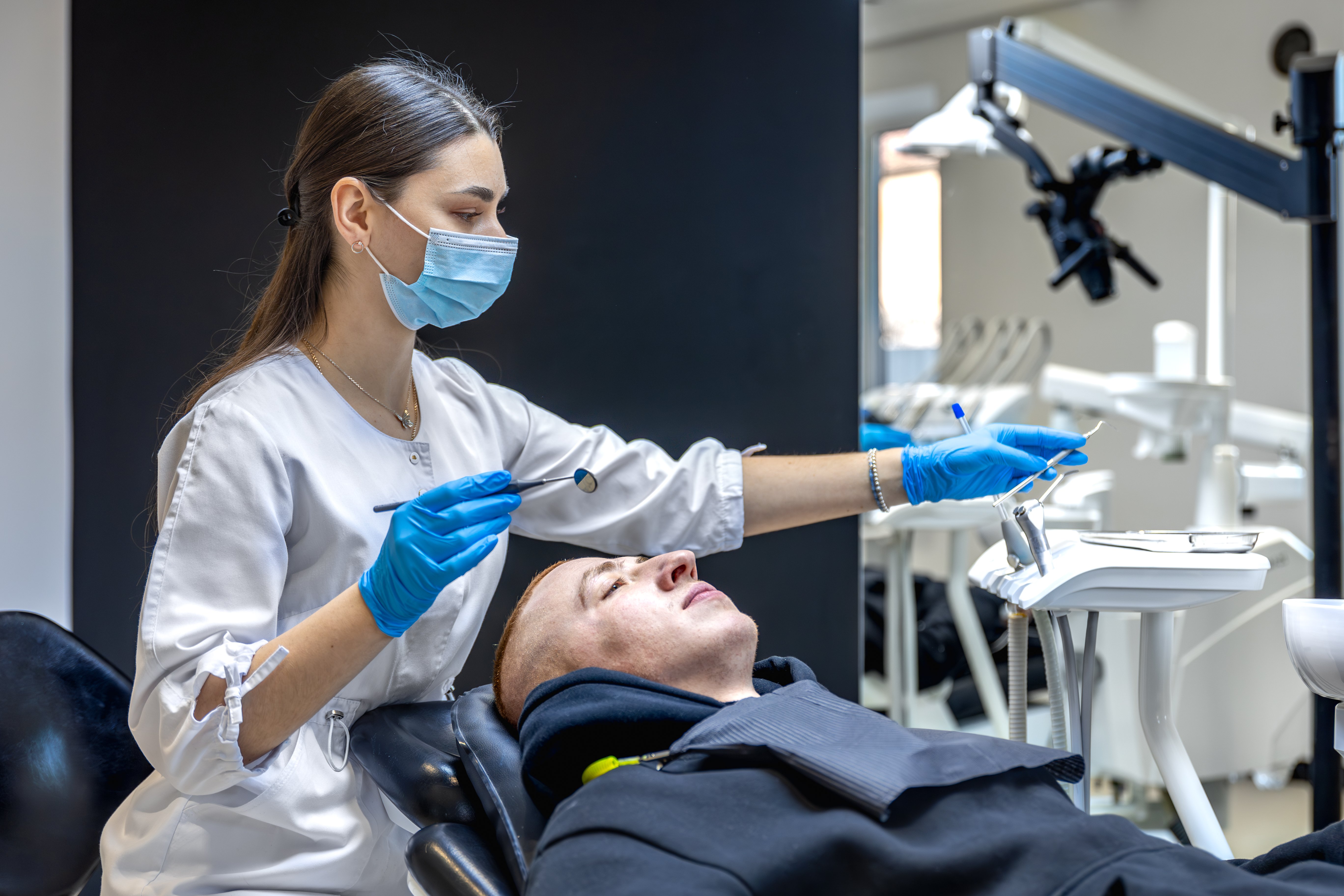 female-dentist-treats-patients-teeth-stomatologist-working-with-professional-equipment