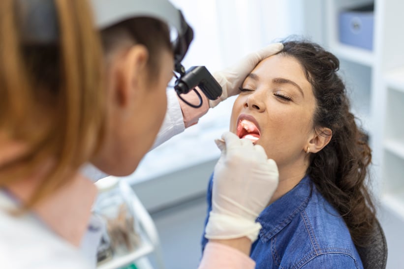 female-patient-opening-her-mouth-doctor-look-her-throat-otolaryngologist-examines-sore-throat-patient
