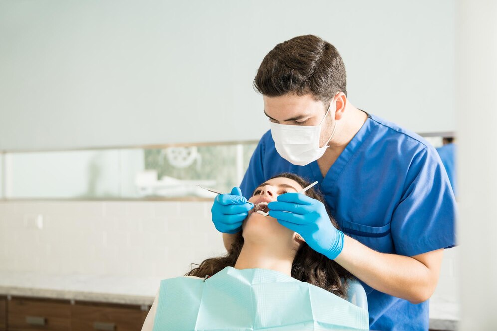 male-dentist-examining-young-woman-with-dental-carver-medical-clinic_662251-2587