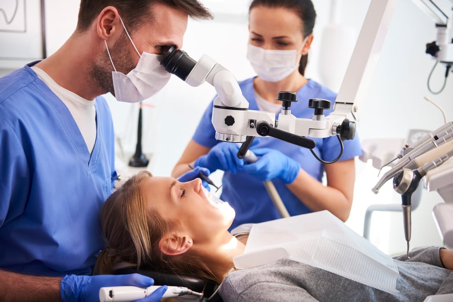 male-dentist-working-with-dental-microscope