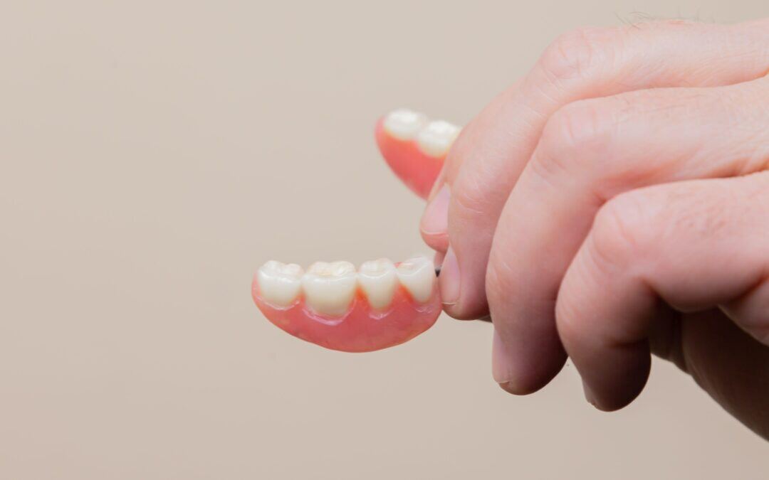 partial-denture-vs-bridge-holding-false-teeth-1080x675