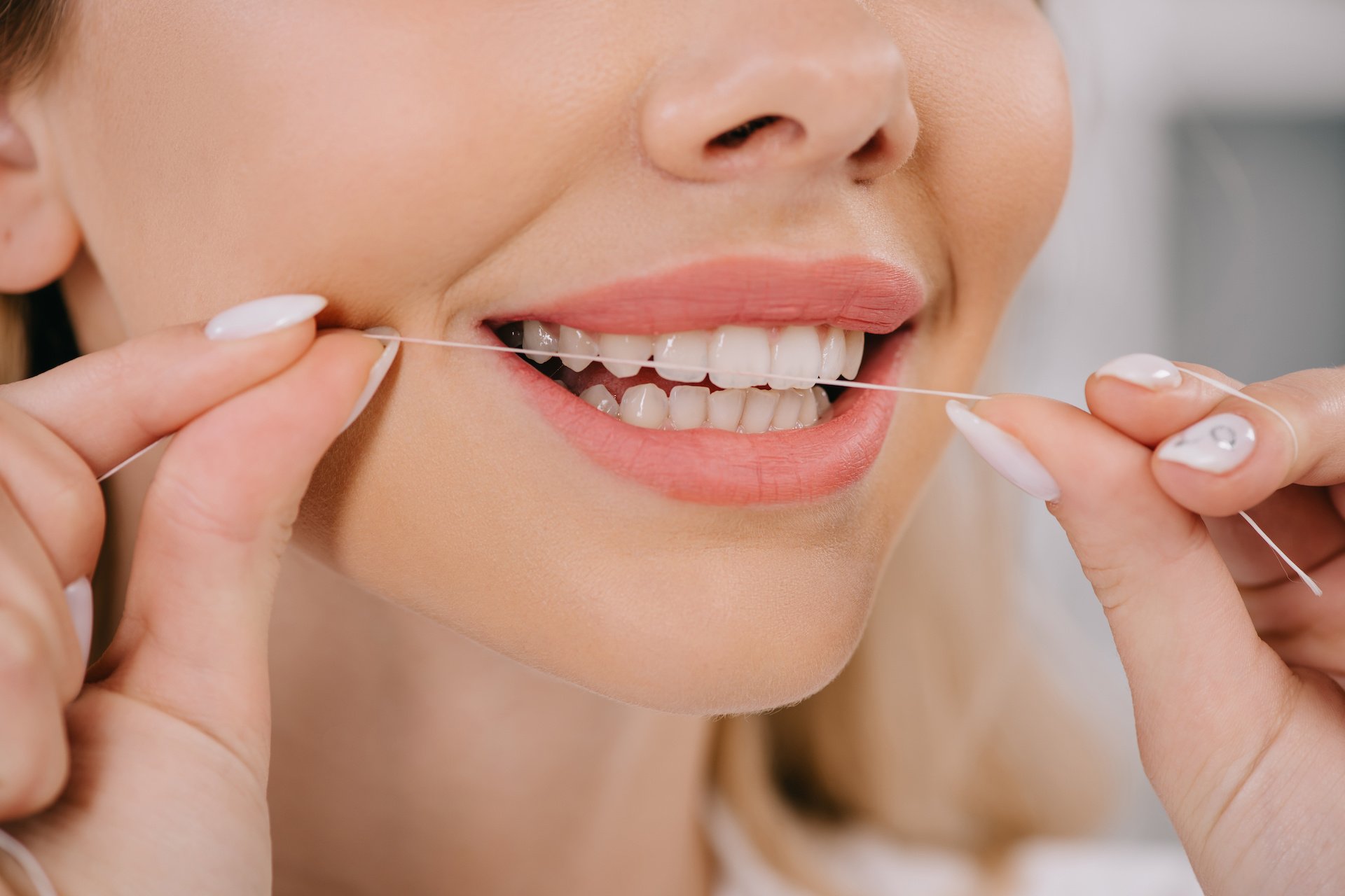 partial-view-of-woman-flossing-teeth-with-dental-f-2022-12-16-16-17-02-utc