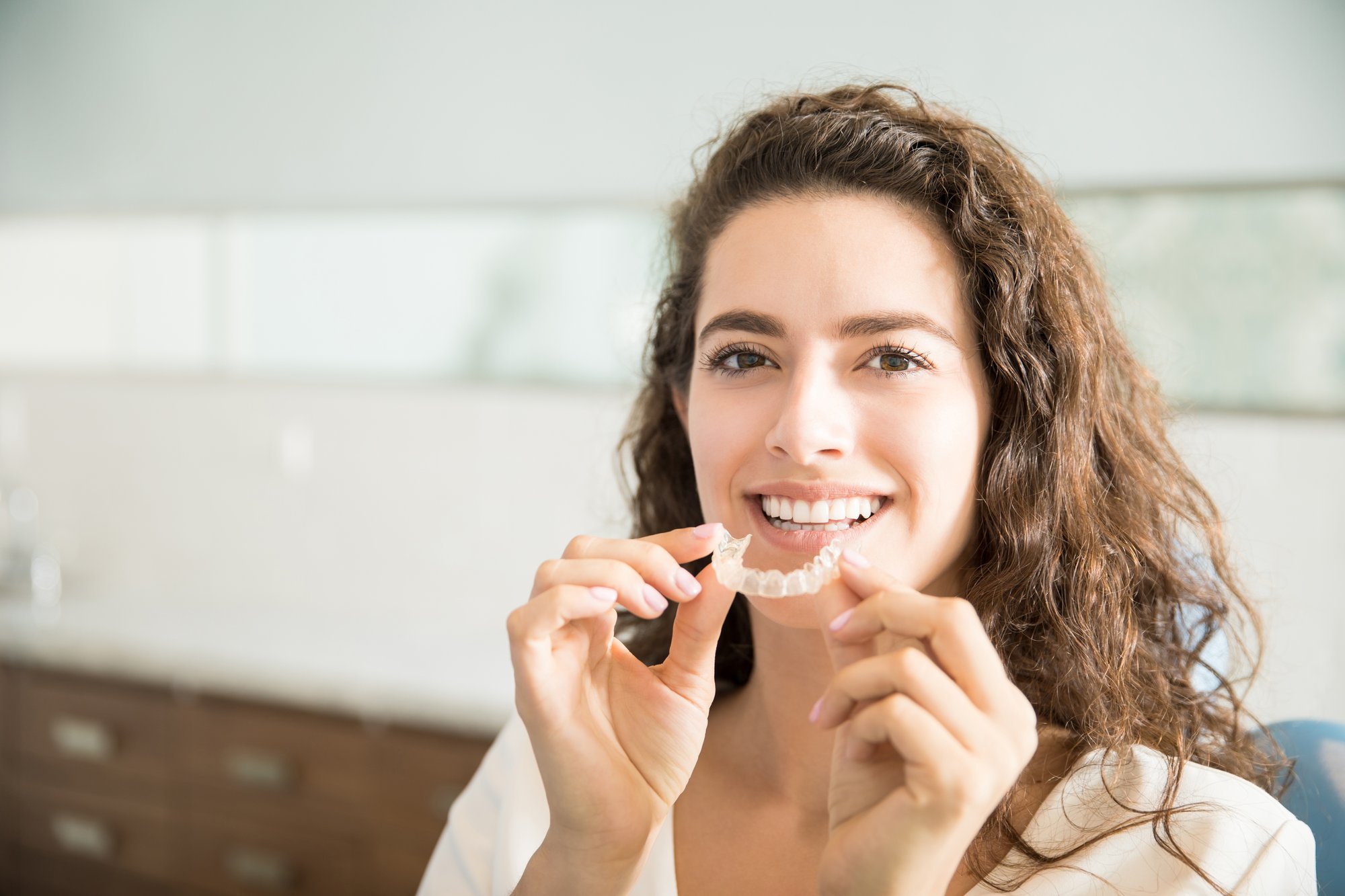 portrait-beautiful-patient-holding-orthodontic-retainers-dental-clinic-1