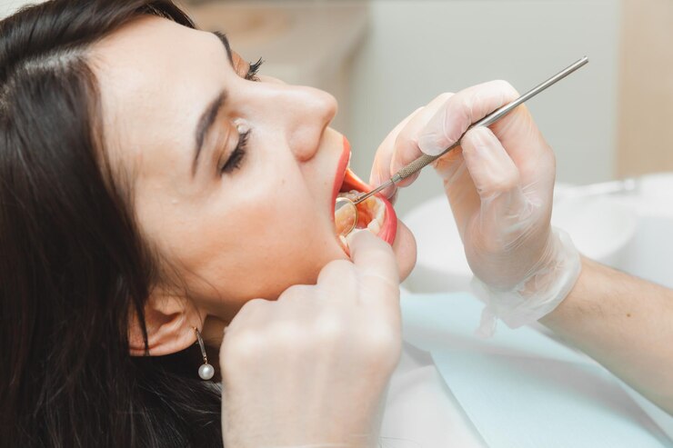 positive-darkhaired-woman-sits-dentist-s-office-checkup-dentist-examining-woman-s-teeth_132375-10239