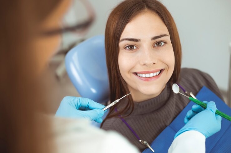 smiling-girl-treats-teeth-while-sitting-dental-chair-doctor_8119-2303