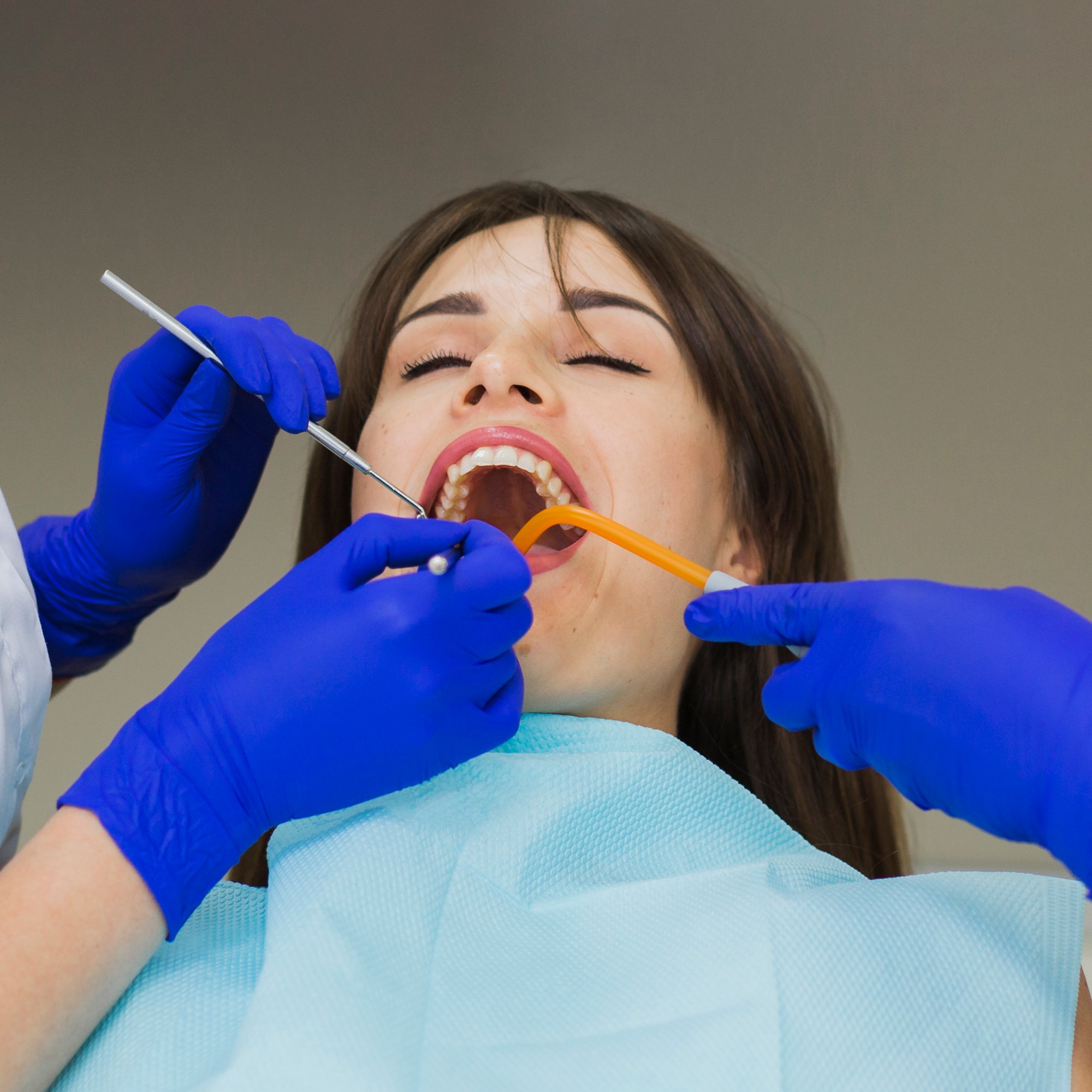 woman-getting-her-teeth-checked-by-dentists