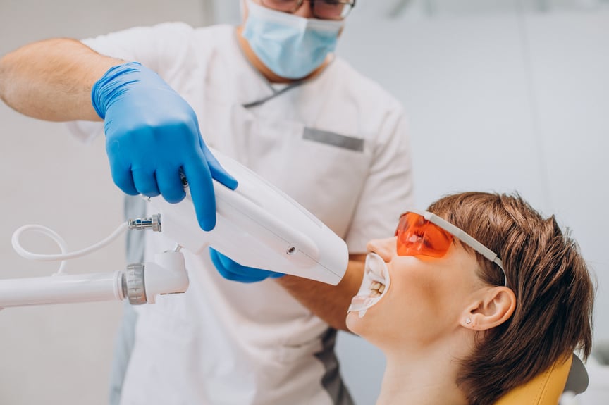 woman-whitening-teeth-dentistry-with-special-equipment