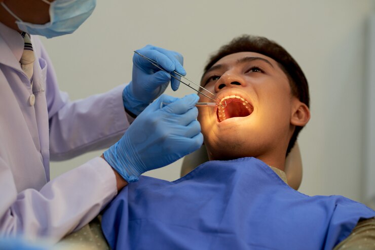 young-man-sitting-mouth-wide-open-office-dentist-annual-examination_1098-20340