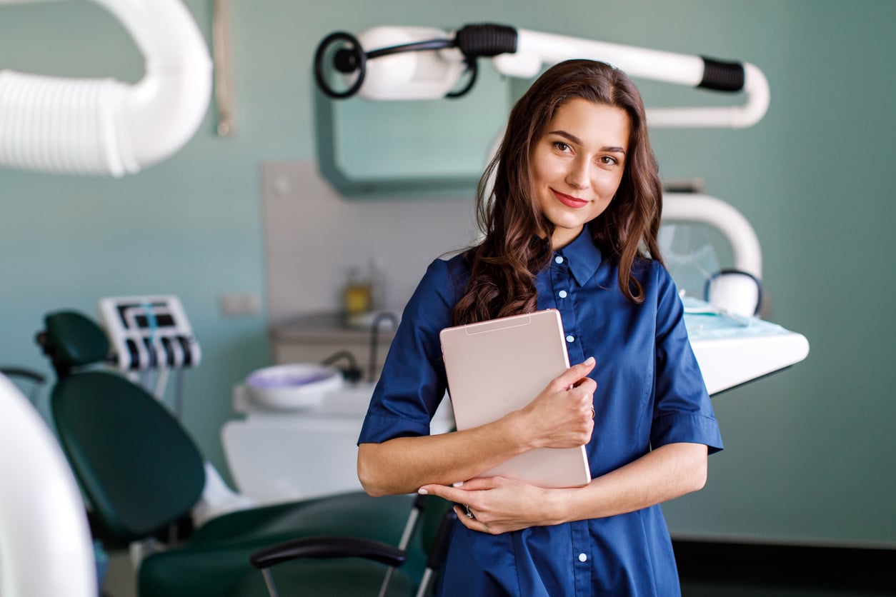 Smiling in the dental office while holding an ipad